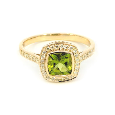 9ct Yellow Gold Peridot & Diamond-set Ring This cluster dress ring is bezel-set with a 1 carat cushion-cut Peridot in the centre and surrounded by 15 points of Round Brilliant Cut Diamonds as well as down the shoulders. Peridot= 1.00ct Cushion Cut TDW= 0.15cts J-K/Si RBCs